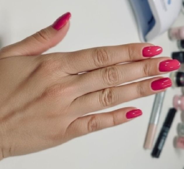 Long oval acrylic nails in a vivid raspberry pink